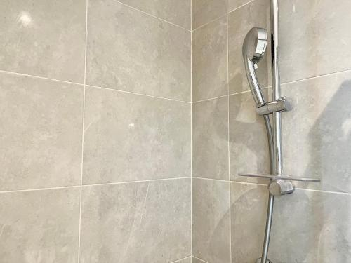 une douche avec pommeau de douche dans une salle de bain dans l'établissement Petit appartement agréable au cœur du 11e arrondissement, à Paris