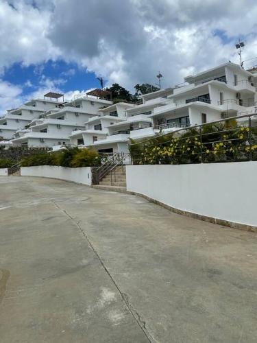 a large white apartment building with a white wall at Serenity Blue Las Terrenas in Las Terrenas
