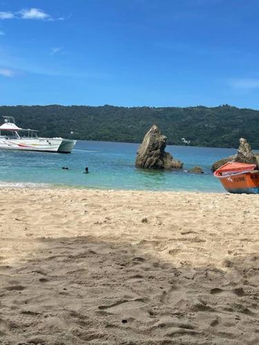 a sandy beach with two boats in the water at Serenity Blue Las Terrenas in Las Terrenas
