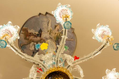 a chandelier hanging from a ceiling with a painting at Palazzo dei Mori in Venice
