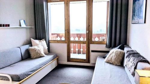 un salon avec un canapé et une grande fenêtre dans l'établissement Résidence Themis - 2 Pièces pour 5 Personnes 04, à Mâcot La Plagne