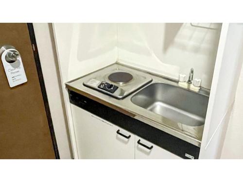 a small kitchen with a sink and a stove at Takatsuki W&M Hotel - Vacation STAY 02641v in Takatuki