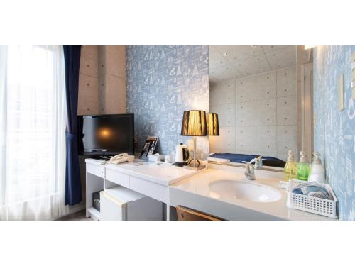 a bathroom with a sink and a tv on a counter at Asuka Hotel - Vacation STAY 59970v in Karatsu