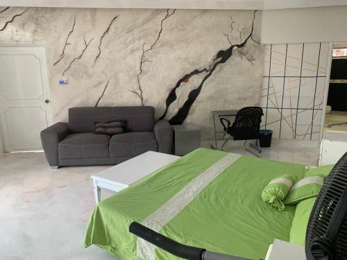 a bedroom with a green bed and a couch at Casa de fin de semana en Tequesquitengo, Mor in Tequesquitengo