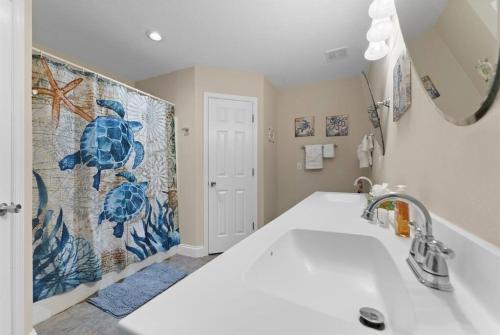 a bathroom with a sink and a mosaic wall at Wander by the Waves Pet Friendly in Palm Coast