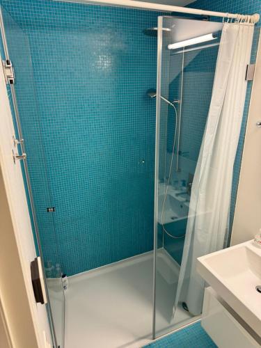 a bathroom with a shower with blue tiles at Exclusive Rooftop Duplex Penthouse - 200sqm - 280 Panoramic Views - Downtown in Basel