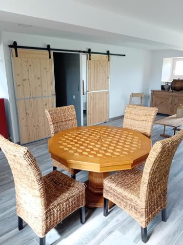 une salle à manger avec une table et des chaises en bois dans l'établissement Chez Tata Madeleine, à Montbras