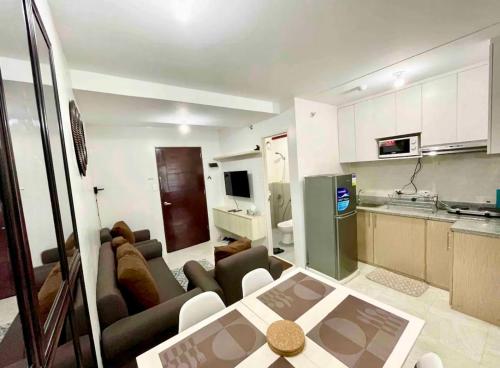 una cucina e un soggiorno con divano e tavolo di Condo Unit in Banilad Mandaue Cebu - 1 to 3 pax booking granted a 1 bedroom unit of your choice and a minimum of 4 guests for a 2 bedroom unit a Mandaue