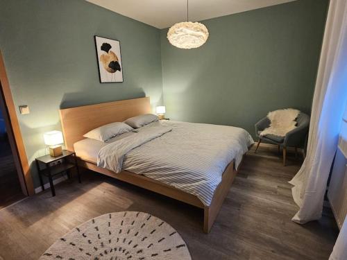 a bedroom with a bed and two tables and a chair at Traumwohnung mit Terrasse und Garten in Ergolding