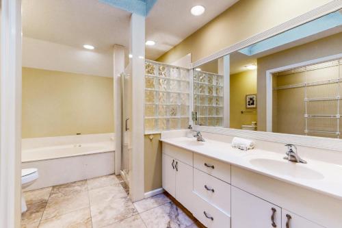 a bathroom with two sinks and a tub and a toilet at Eagle Watch in Hilton Head Island