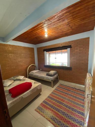une chambre avec deux lits et un tapis dans l'établissement Casa do Rafael, à Conceição da Ibitipoca