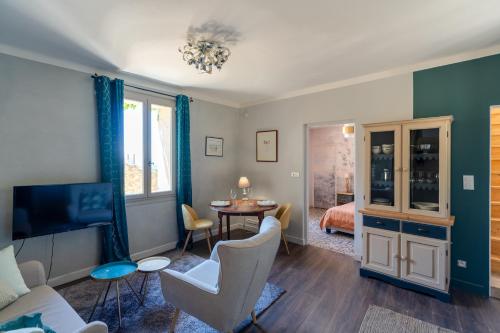 een woonkamer met een bank en een eetkamer bij Maison de village panoramique in Châteauneuf-du-Pape