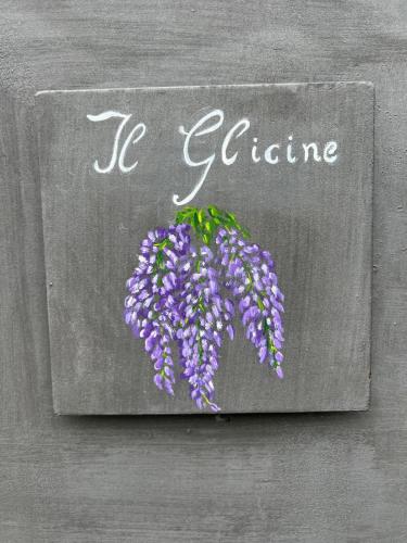 a sign that says be culture with a bunch of purple flowers at Il Glicine in Camaione