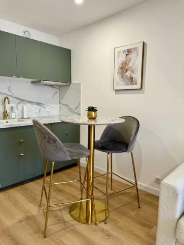 a kitchen with a table and two chairs at Golden Duplex Chic - Centre-Clim-Parking in Narbonne