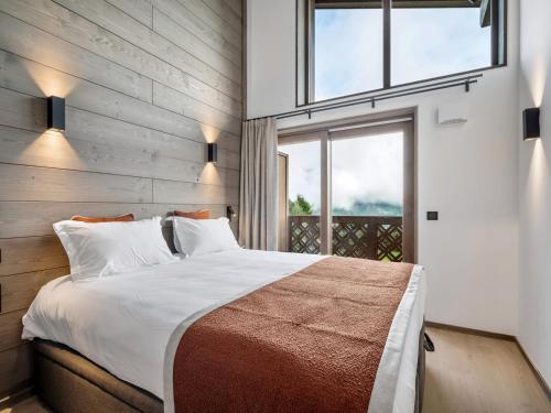 une chambre avec un grand lit et une fenêtre dans l'établissement Appartement Neuf à Courchevel le Praz, 2 Chambres, Proche Pistes, Parking Inclus - FR-1-568-51, à Courchevel
