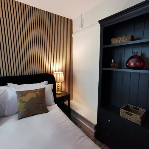 a bedroom with a bed with a black headboard and a lamp at The Swinside Inn in Keswick