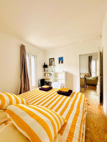 - 2 lits dans une chambre à rayures jaunes et blanches dans l'établissement Cosy, climatisé, au coeur de Sète, à Sète