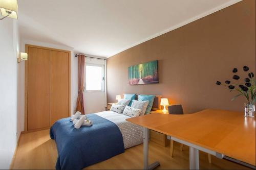 - une chambre avec un lit et une table en bois dans l'établissement Cardoso Pires 2 Bedrooms Apt., à Lisbonne
