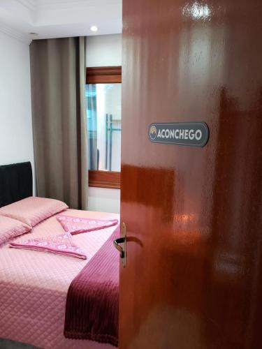 a door with a sign on it next to a bed at Pousada Monte Sião in Sao Paulo