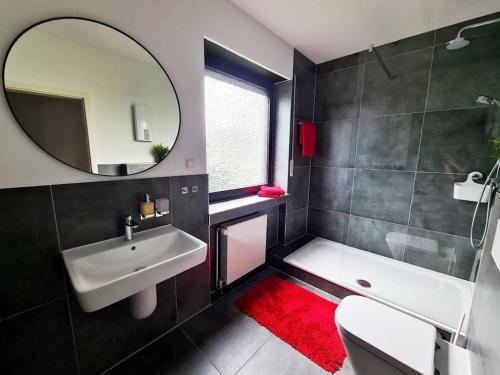 a bathroom with a white sink and a mirror at Renovierte Doppelhaushälfte in bester Lage in Bottrop