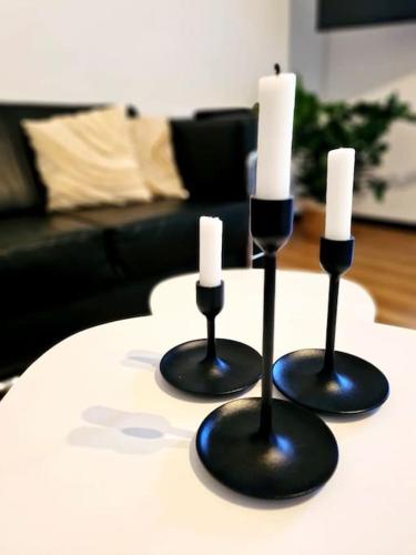 two black candlesticks with white candles on a table at Renovierte Doppelhaushälfte in bester Lage in Bottrop