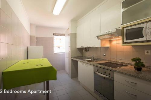 een keuken met een groen eiland in het midden bij Cardoso Pires 2 Bedrooms Apt. in Lissabon