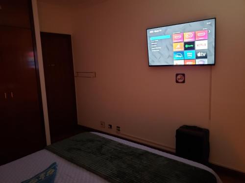 a bedroom with a flat screen tv on the wall at Pousada Monte Sião in Sao Paulo
