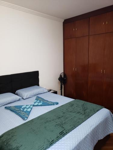 a bedroom with a bed and a wooden cabinet at Pousada Monte Sião in Sao Paulo