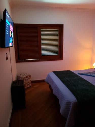 a bedroom with a bed and a flat screen tv at Pousada Monte Sião in Sao Paulo