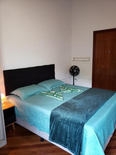 a bedroom with a large bed with a blue blanket at Pousada Monte Sião in Sao Paulo