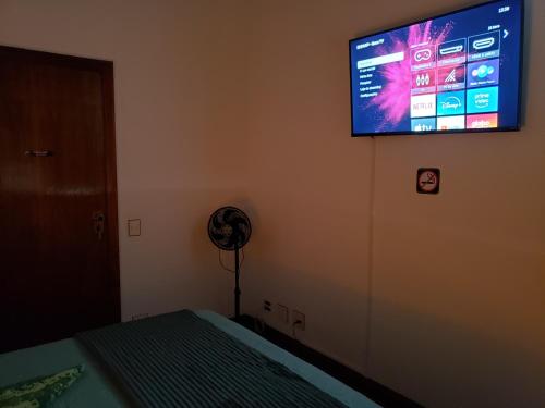 a bedroom with a flat screen tv on the wall at Pousada Monte Sião in Sao Paulo