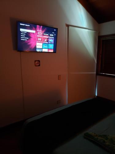 a tv on the wall of a room with a refrigerator at Pousada Monte Sião in Sao Paulo
