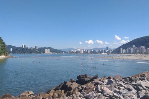 a beach with a bunch of people in the water at Apartamento vista mar Santos in Santos