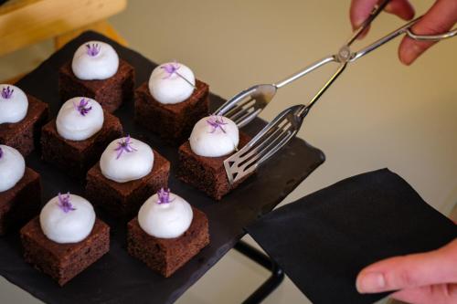 a person holding a fork and a bunch of brownies with white icing at Sheraton Stockholm Hotel in Stockholm