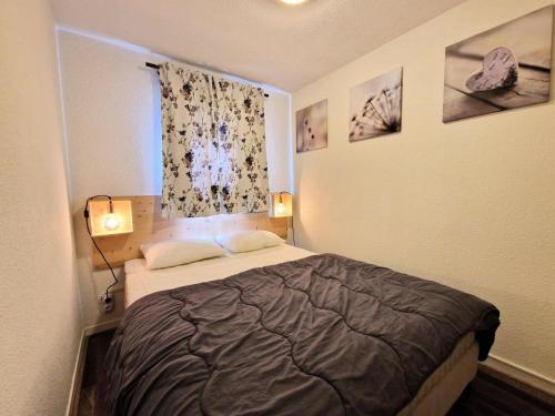 une petite chambre avec un lit et une fenêtre dans l'établissement Résidence Le Cheval Blanc - 4 pièces 7/9 personnes de 55 m² MAE-9461, à Modane