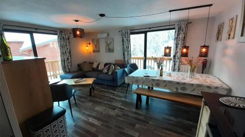 un salon avec un canapé bleu et une table dans l'établissement Résidence Le Cheval Blanc - 4 pièces 7/9 personnes de 55 m² MAE-9461, à Modane