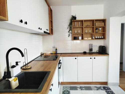 a kitchen with white cabinets and a sink at Apartman Alfa in Smederevo