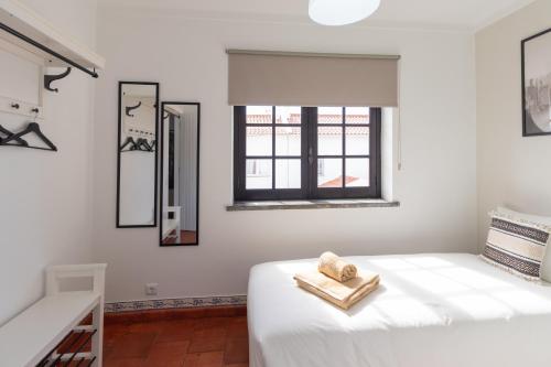 a white bedroom with a bed and mirrors at Baleal Classic Waves Guest House in Baleal
