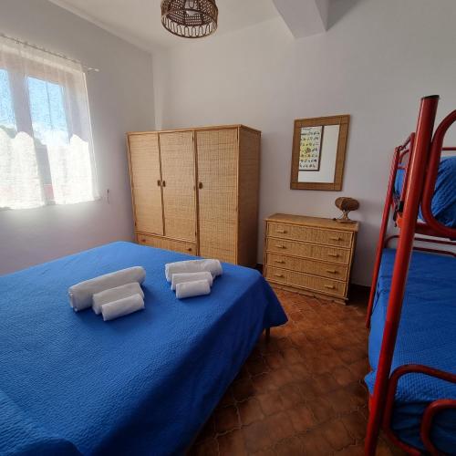 a bedroom with a blue bed with two pillows on it at La Villa di Nino in Ustica