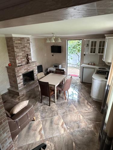 a living room with a table and a fireplace at Villa in Tsikhisdziri in Boboqvat'i