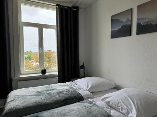 GehrdenにあるModerne 4 Zimmer Apartment mit Bergblick Stadtzentrum Contactless Check-inの窓の前にベッドがある寝室