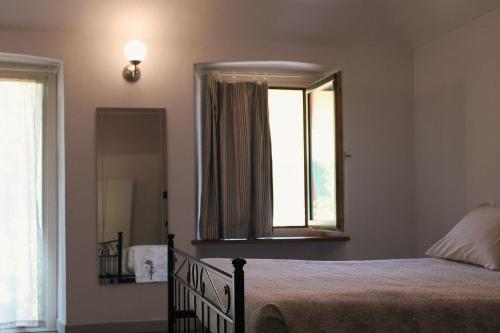a bedroom with a bed with a mirror and a window at Bed&Braja in Vische