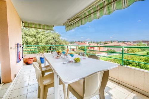 une salle à manger avec une table et des chaises sur un balcon dans l'établissement Appartement Le Sambora - Happy Rentals, à Fréjus