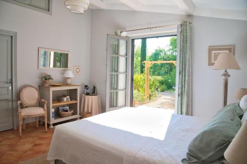 une chambre blanche avec un lit et une fenêtre dans l'établissement Les Apiers, chambre d'hôtes de charme à Carcès, à Carcès