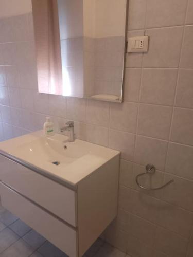 a white bathroom with a sink and a mirror at Casa Iris in La Spezia