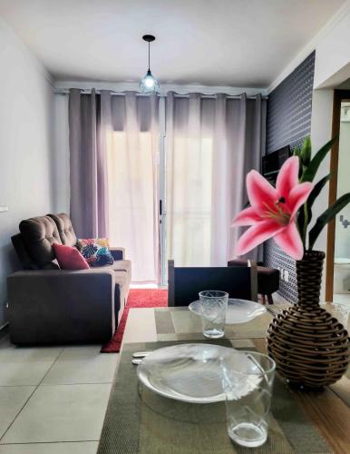 una sala de estar con un sofá y una mesa en BEM no CeNtRo, cozinha completa, varanda e garagem, en Poços de Caldas