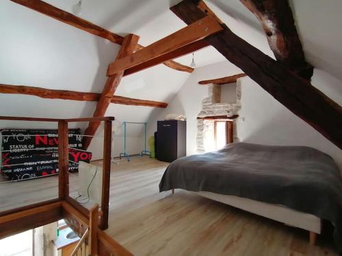 - une chambre mansardée avec des poutres apparentes dans l'établissement Charmant studio au cœur du Quercy, à Varaire