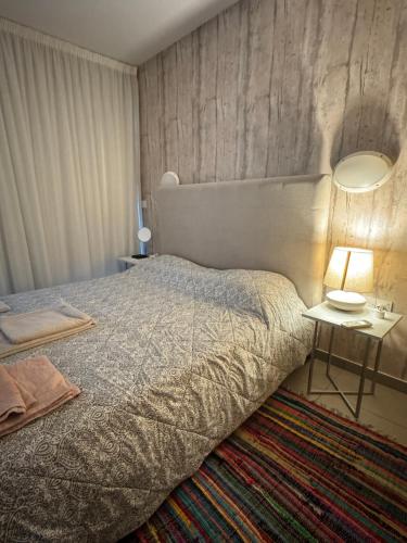 a bedroom with a bed and a table with a lamp at One-bedroom beach apartment, 30m from an amazing beach, Coralli in Protaras