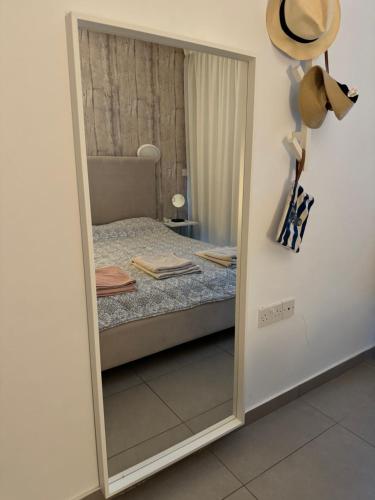a mirror in a bedroom with a bed at One-bedroom beach apartment, 30m from an amazing beach, Coralli in Protaras