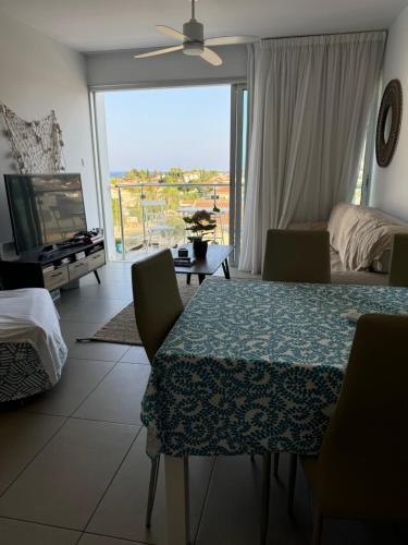 a living room with a table and a view of a bedroom at One-bedroom beach apartment, 30m from an amazing beach, Coralli in Protaras